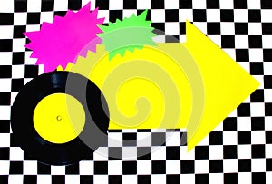 Photograph of 45rpm record with colorful shapes on Checkered floor photo