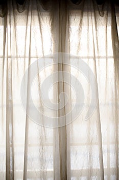 Sheer fabric window curtain with filtered light photo