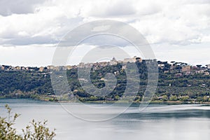 Photograph taken in Castel Gandolfo, Italy, featuring a view of the lake and mountains with a distant cityscape