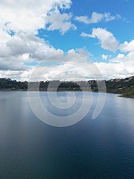 Photograph taken in Castel Gandolfo, Italy, featuring a view of the lake and mountains with a distant cityscape