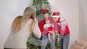 Photograph taking pictures of a happy family on Christmas eve at cozy home