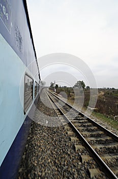 A photograph of a train traveling with parallel railway tracks.