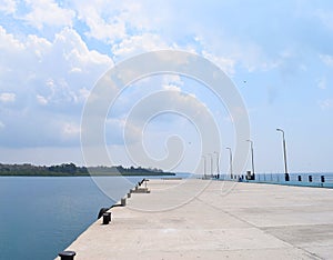 Uncrowded Ferry Jetty with Open Sea and Cloudy Sky photo