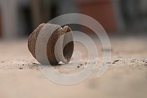 A photograph of a used Earthen pot lying around.