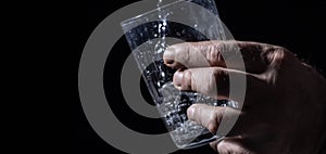 Photograph of water poured into a glass with a black background.