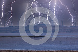 Photograph of Wind Turbines on a hill during a lightning storm