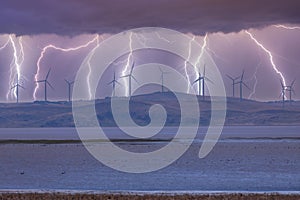 Photograph of Wind Turbines on a hill during a lightning storm