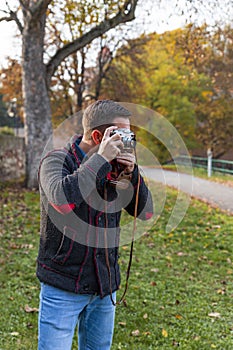 Photographer with analogue film camera outdoors