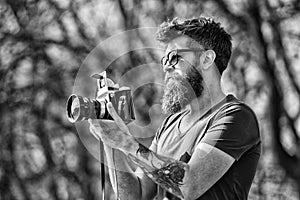 Photographer with beard and mustache amateur photographer nature background. Man with long beard busy with shooting