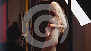 Photographer and beauty blonde female model in photo studio - photographer`s working