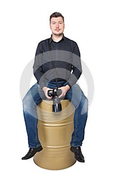 Photographer with camera sitting on an iron barrel