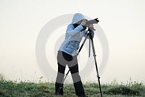 photographer with camera and tripod outdoor taking landscape picture