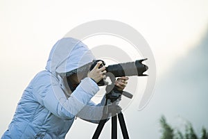 photographer with camera and tripod outdoor taking landscape picture