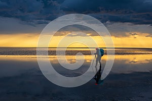 Photographer capturing sunset at calm reflective lake