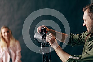 Photographer controlling the studio flash strobe lighting head.