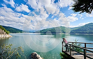 Photographer female on the lake Vidraru Carpathians Romania