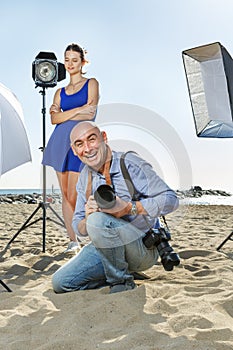 Photographer with female model on sea coast