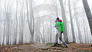 Photographer in foggy forest