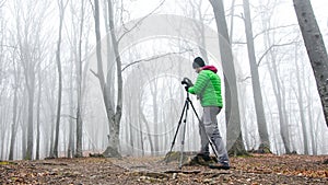 Photographer in foggy forest