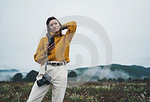 Photographer girl hold in hands mobile phone photo camera on background autumn froggy mountain, tourist enjoy nature mist landscap