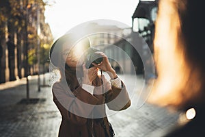 Photographer in glasses with retro camera take photo model girlfriend. Tourist smile girl in hat travels in Barcelona holiday