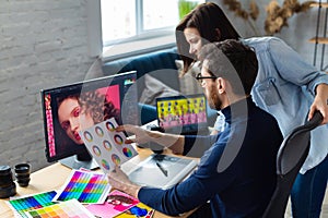 Photographer and graphic designer working in office with laptop, monitor, graphic drawing tablet and color palette photo