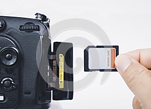Photographer hand insert memory SD card to memory slot of the digital DSLR camera
