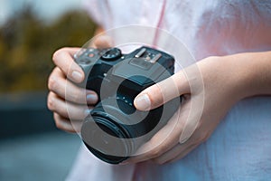 Photographer hands holding a digital camera, focusing and taking photos, macro closeup