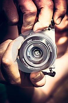 Photographer holding photo camera lens taking photo grunge street style. Photography lifestyle concept