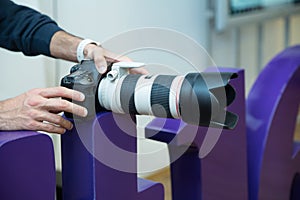 The photographer is holding a Camera Canon EF 70-200mm f 2.8L USM Lens . A canon 70-200 L lens close up