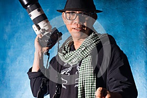Photographer holding camera with white zoom lens.