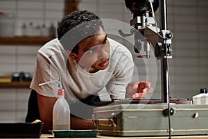 Photographer intently adjusts an enlarger in