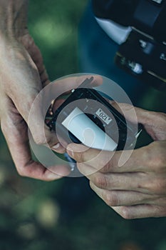 Photographer loading medium format film into the film back