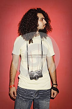 Photographer looking sidewise with beautiful long curly hair holding camera