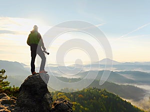 Photographer looks into the landscape and listen the silence. Man prepare camera to takes photos