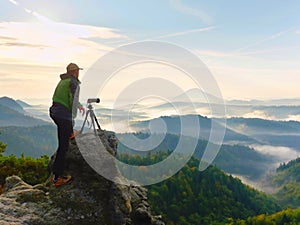 Photographer looks into the landscape and listen the silence. Man prepare camera to takes photos