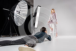 photographer lying and shooting beautiful female model