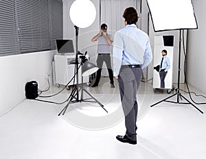 Photographer, model and lighting with equipment in studio for career, behind the scenes or electronics. Photography