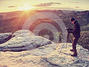 Photographer on mountain cliff take picture of landscape awaking