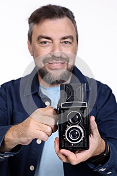 Photographer with an old retro camera, smiling. Studio shot