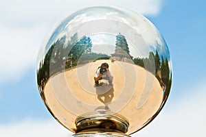 Photographer and pagoda in a metal ball