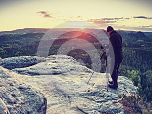 Photographer prepare camera to takes photos of countryside