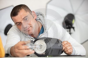 photographer prepares flash unit and studio light