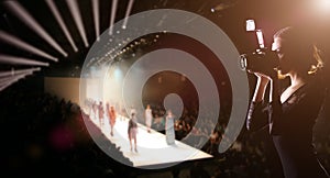 Photographer Press Woman use Camera to shoots Photo of Fashion Week Show which Model Supermodel walk on Runway Catwalk for New