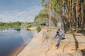 Photographer relaxes in nature near the river