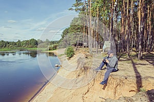 Photographer relaxes in nature near the river