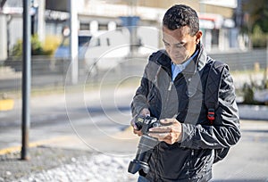 Photographer reviewing the photographs on his camera on the street