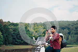 Photographer riding a motor scooter on road. Traveled by scooter slow life on vacation resting time