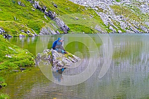 Photographer on a rock on a lake