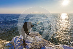 Photographer on the rocks taking landscape pictures